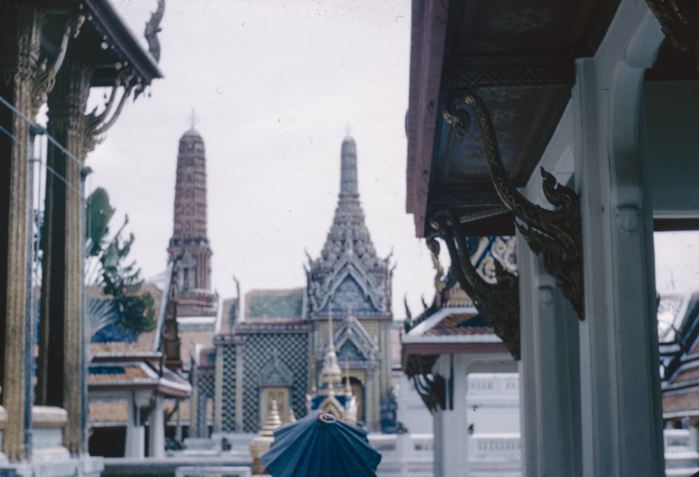 a person with a blue umbrella standing in front of a building