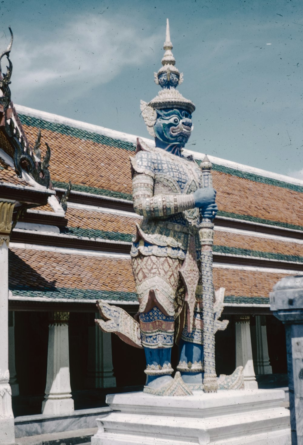 a statue in front of a building with a sky background