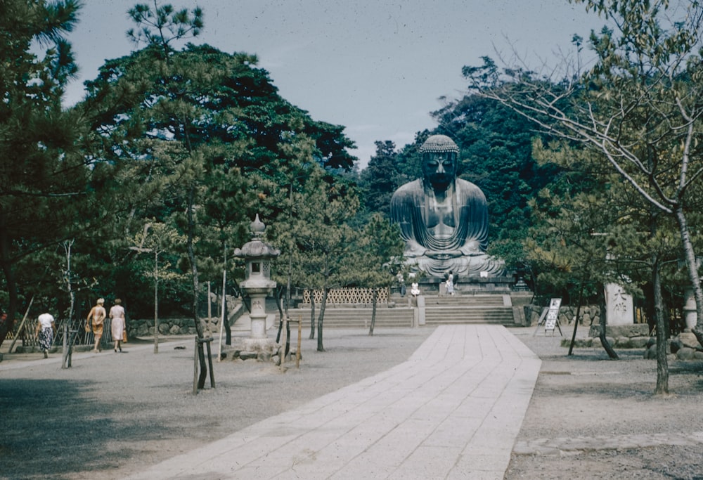 a large buddha statue sitting in the middle of a park