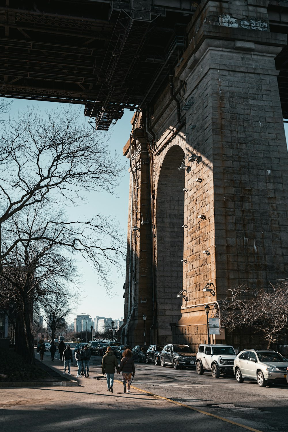 a group of people walking under a bridge