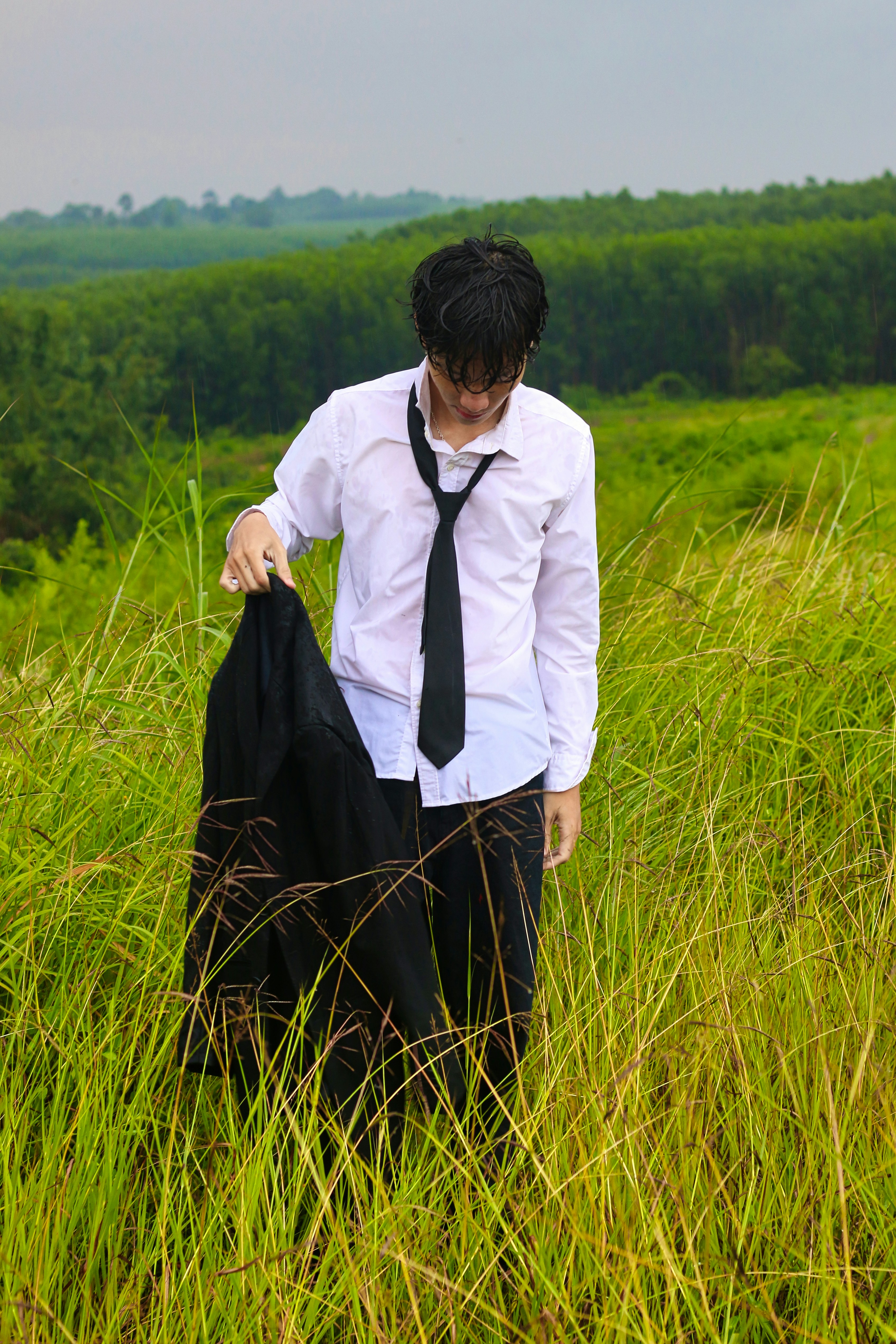 a man in a tie is standing in a field