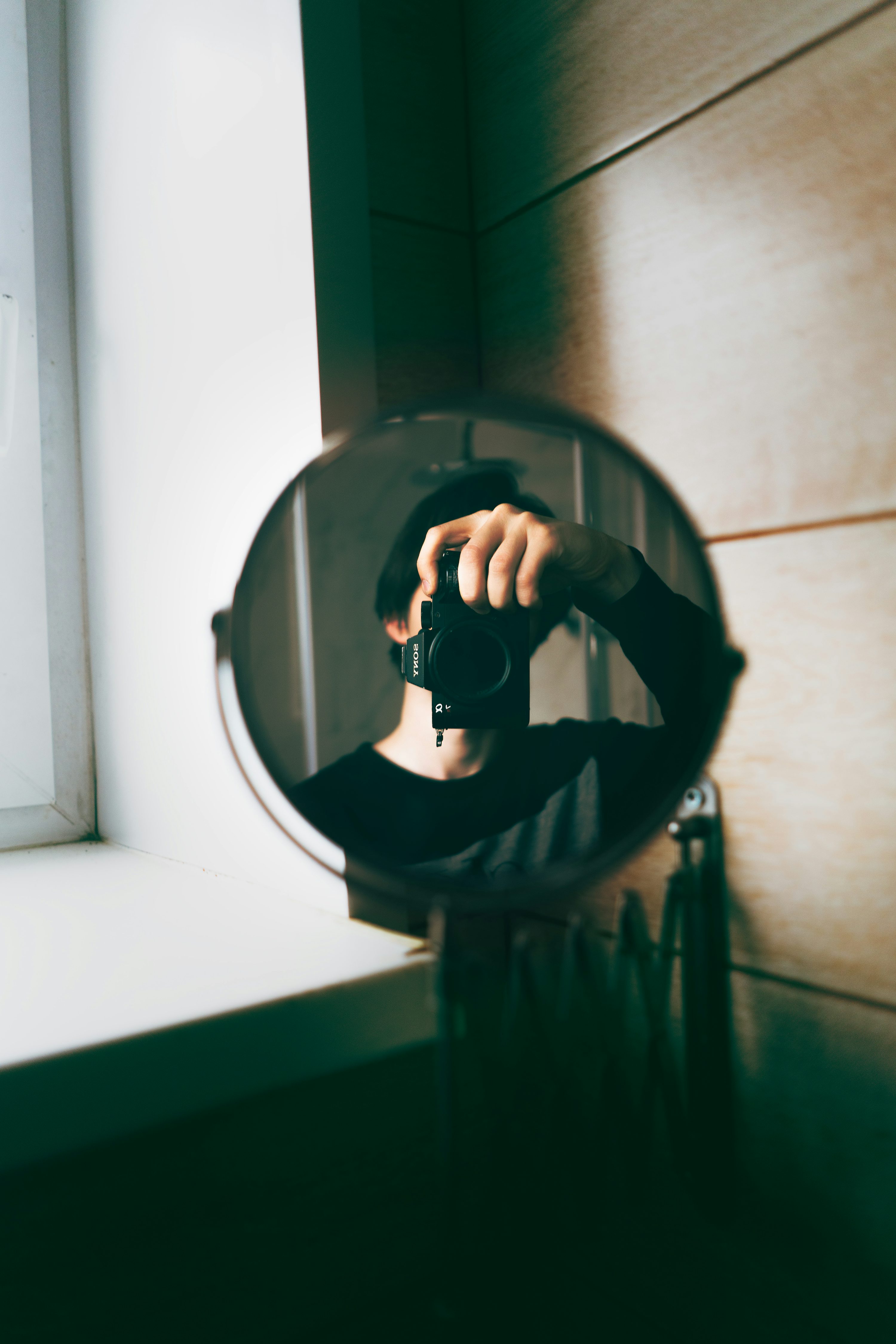 a person holding a camera in front of a mirror