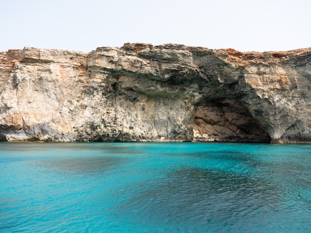 a large body of water near a rocky cliff