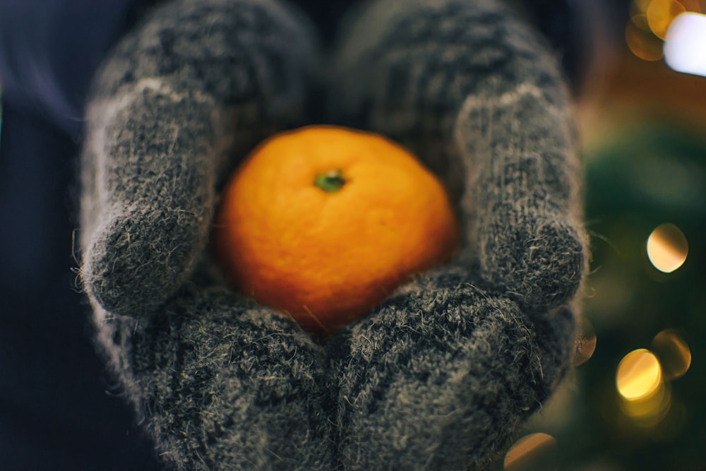a person holding an orange in their hands