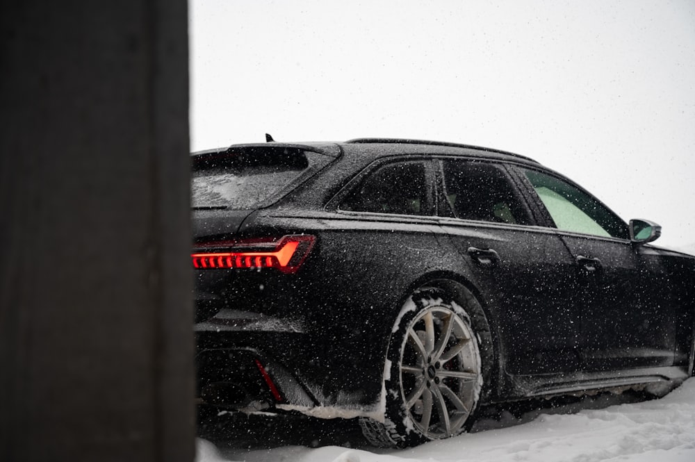 a black car is parked in the snow