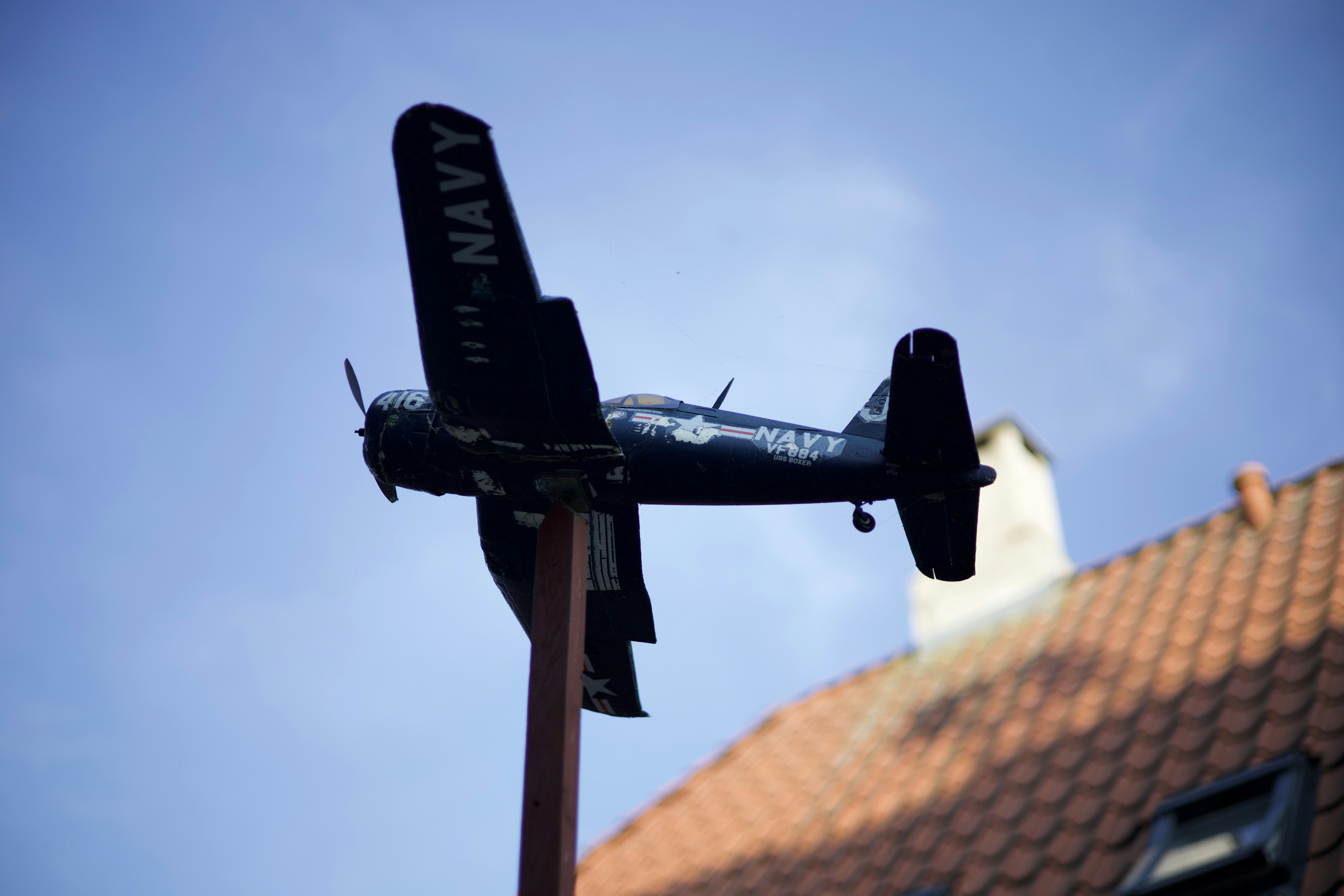 a model airplane is flying over a building