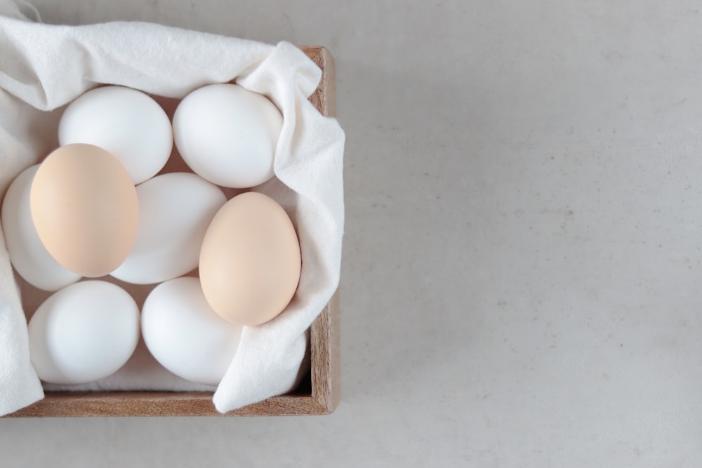 una caja de madera llena de huevos encima de una mesa