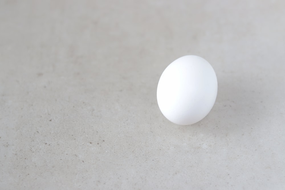 ein weißes Ei, das auf einem weißen Tisch sitzt