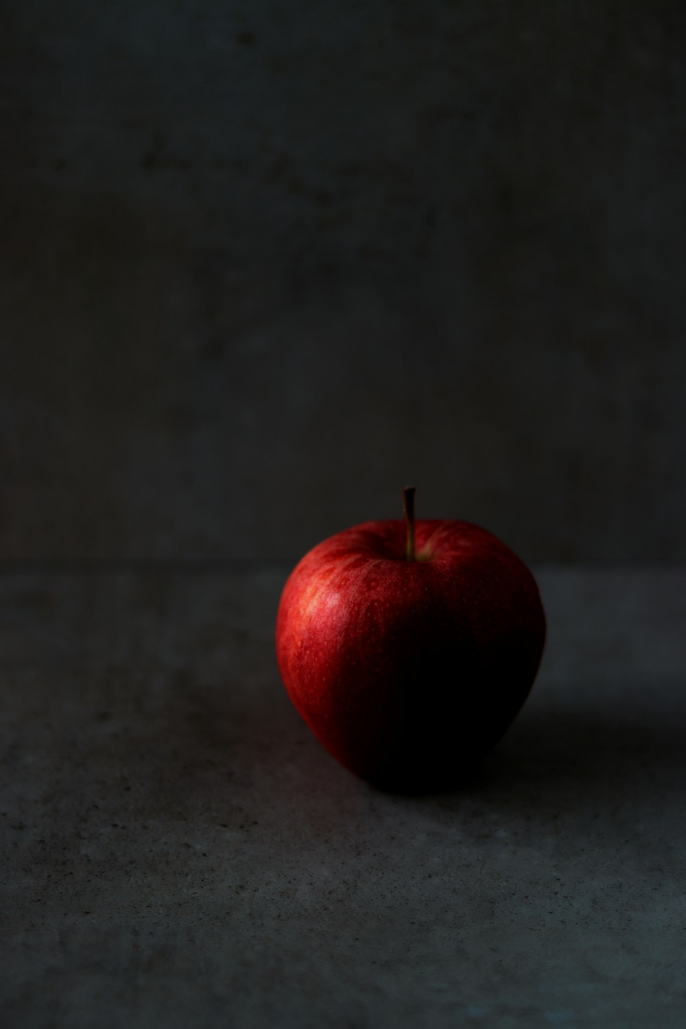 uma maçã vermelha sentada em cima de uma mesa