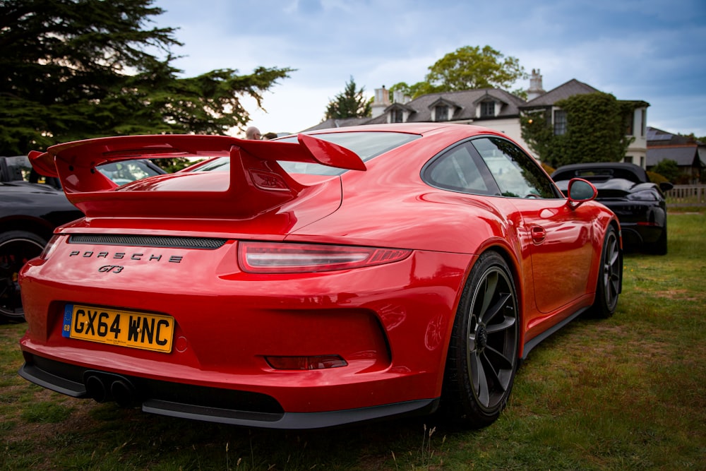 a red porsche sports car parked in a field