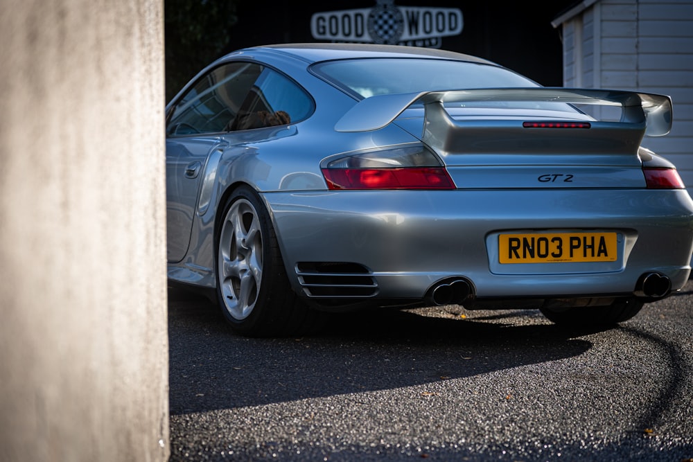 a silver sports car parked in front of a garage