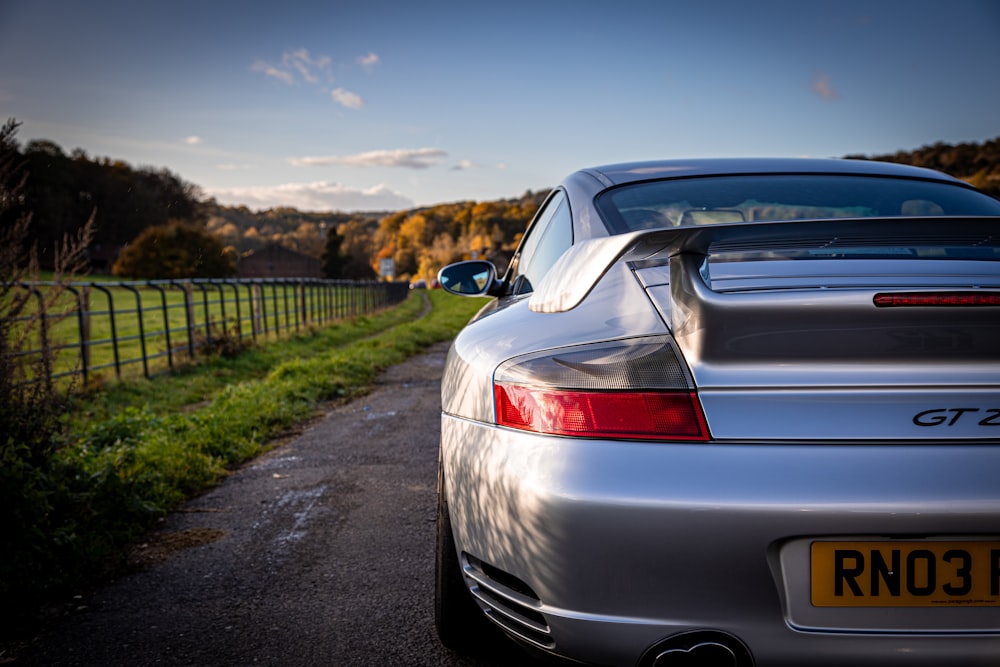 a silver sports car parked on the side of a road