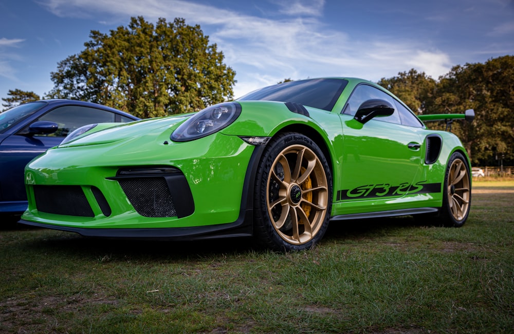 a green sports car parked next to a blue sports car