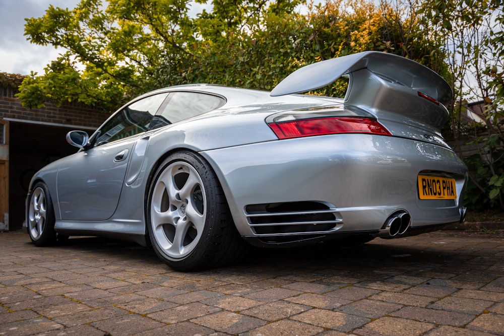 a silver sports car parked in a driveway