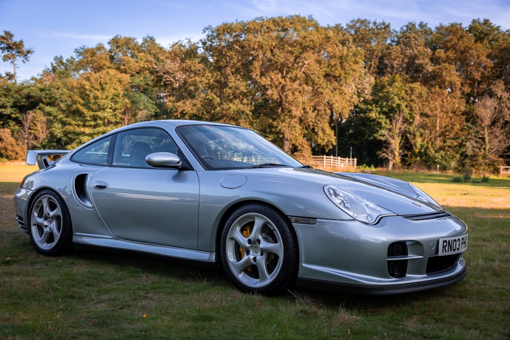 a silver sports car parked in the grass