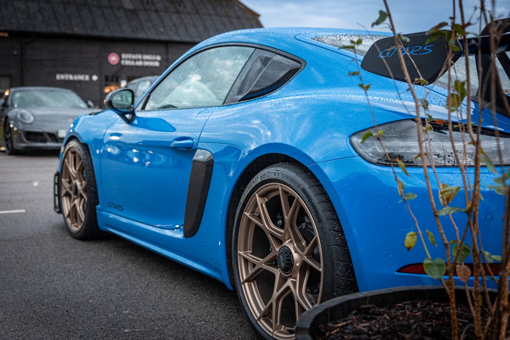 a blue sports car parked in front of a building