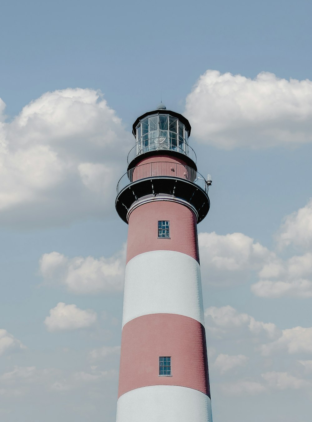 a red and white lighthouse with a sky background