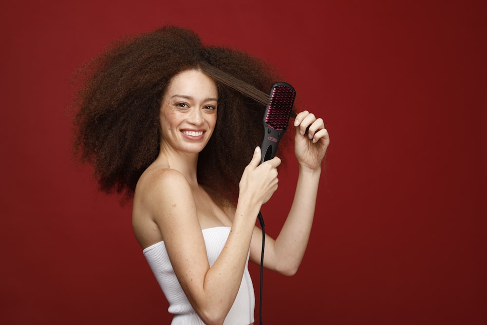 a woman holding a hair brush in her hand