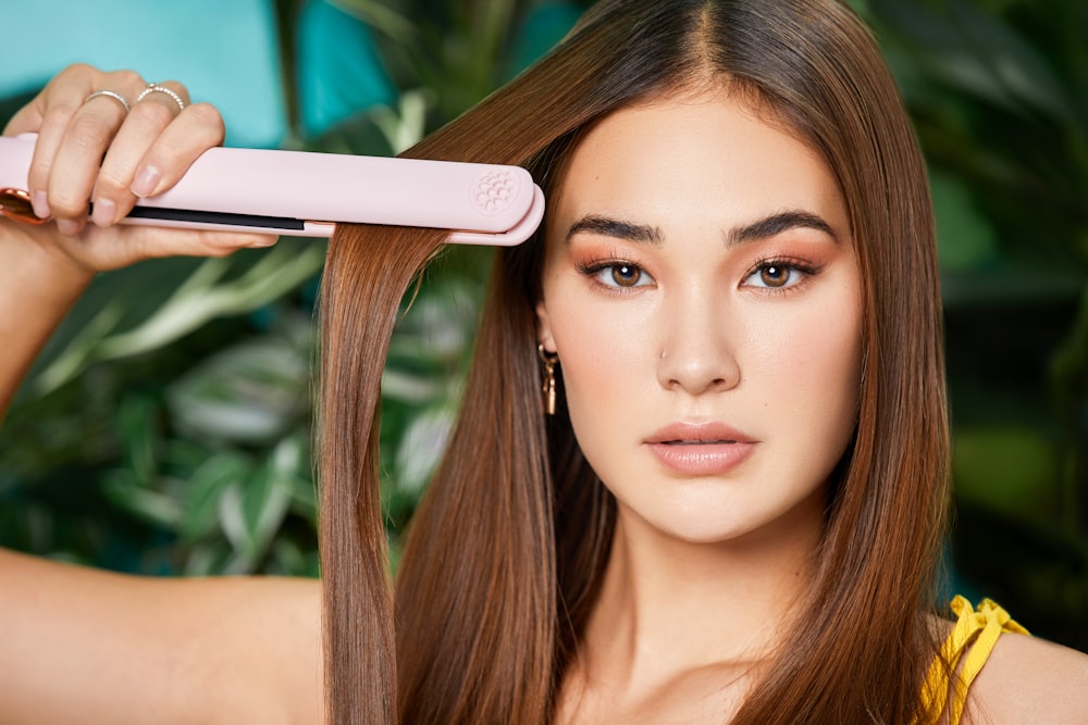 a woman is holding a hair dryer in her hand