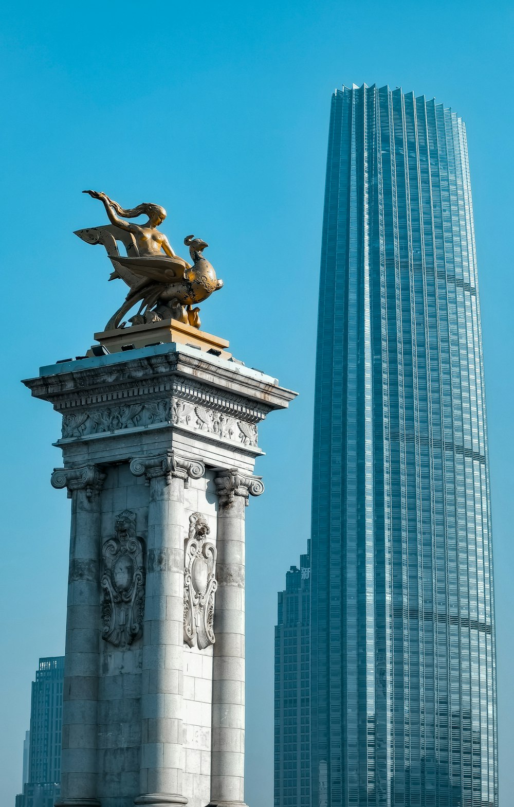 um edifício alto ao lado de uma estátua em frente a ele