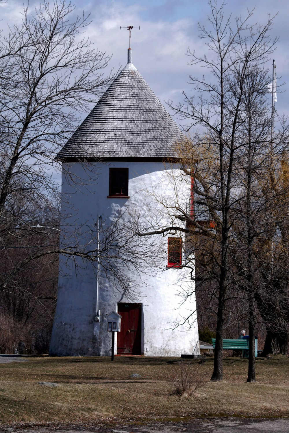 a tall white tower with a red door