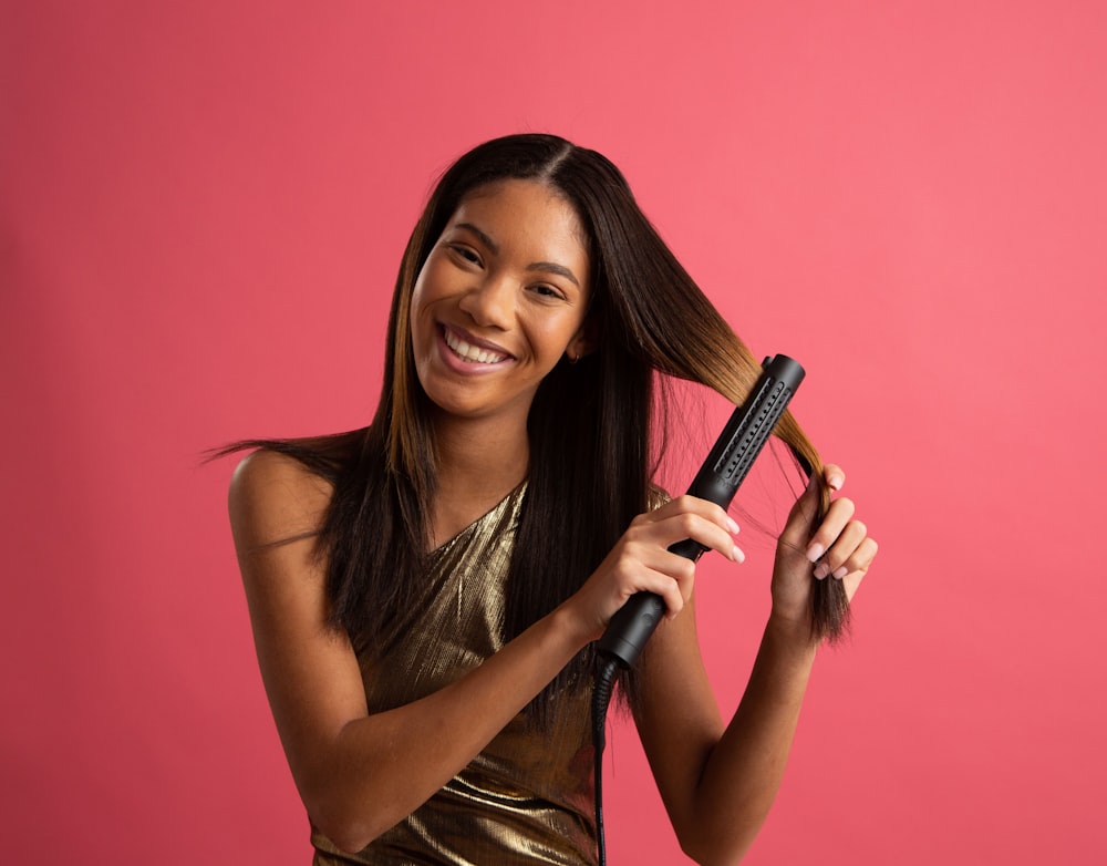 a woman is holding a hair brush and smiling