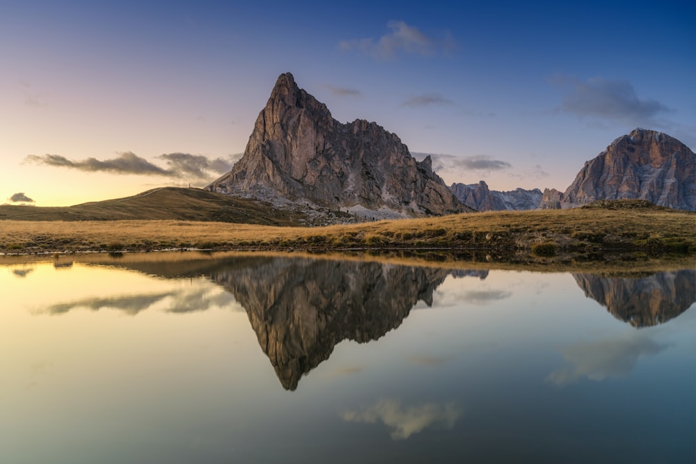 the mountains are reflected in the still water of the lake