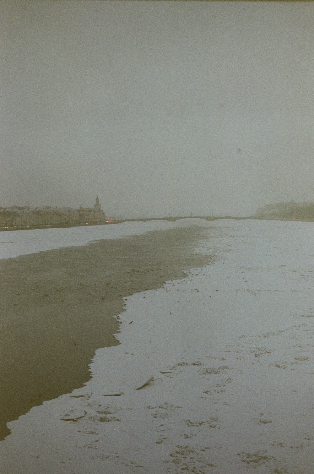 a person walking along a wet beach next to the ocean