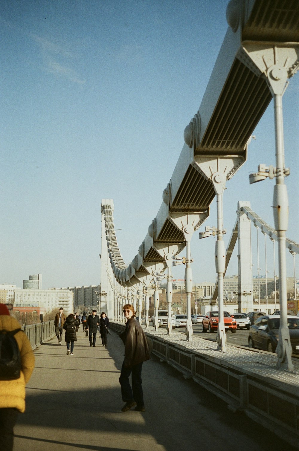 a group of people walking across a bridge