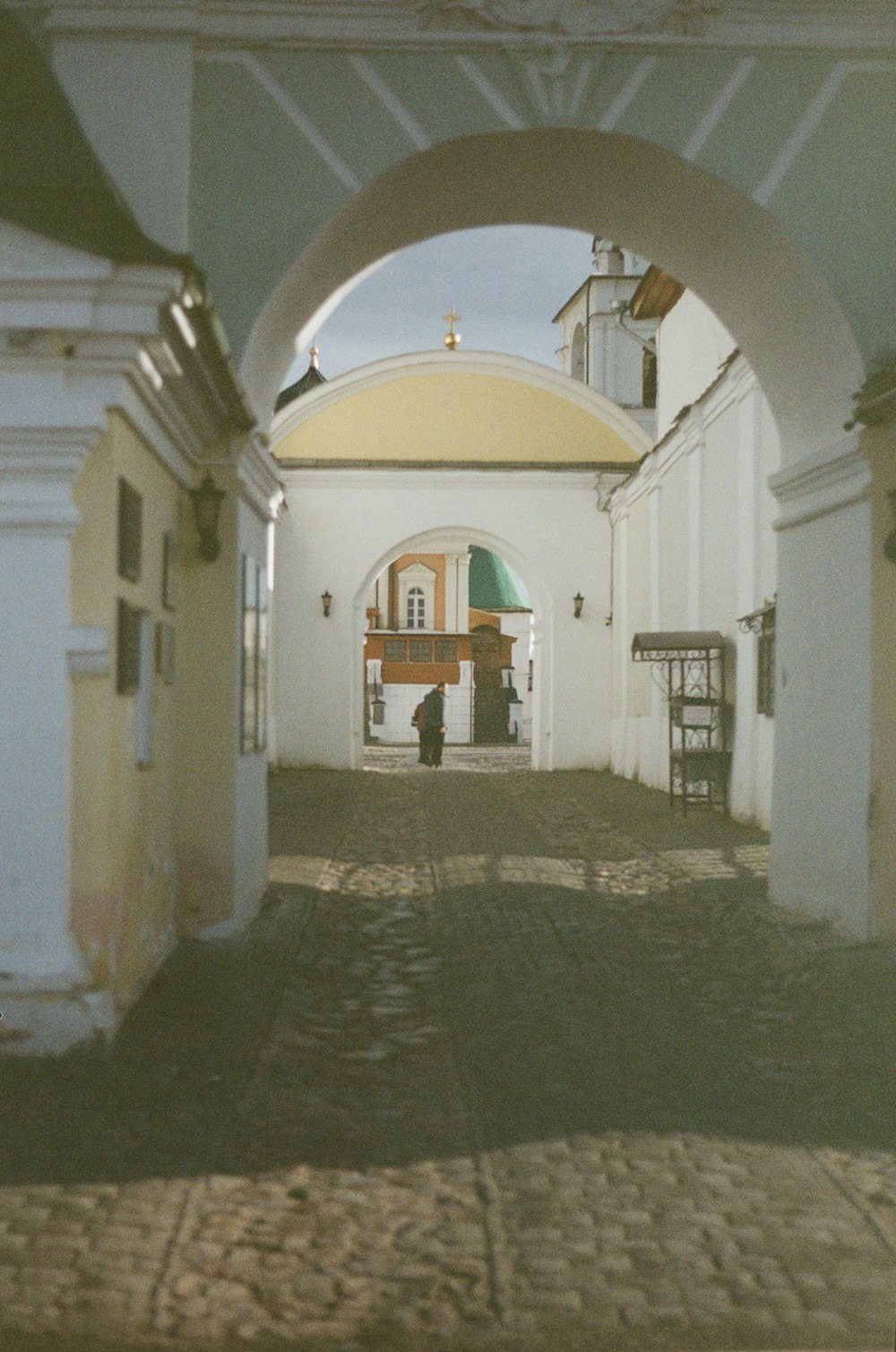 an archway leading into a building with a clock on it