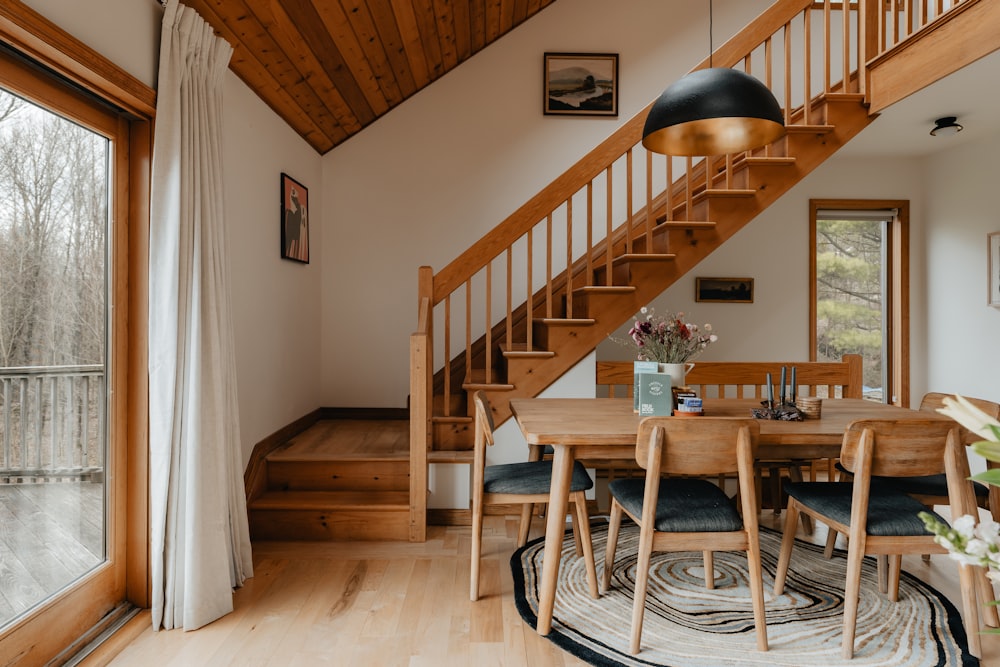 a dining room with a wooden table and stairs