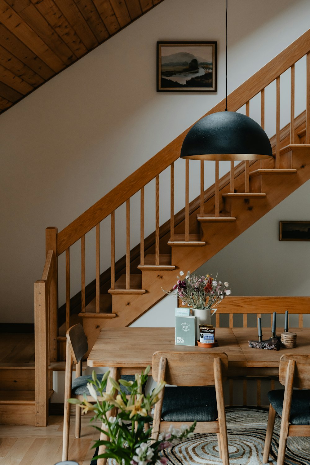 a wooden table sitting under a stair case