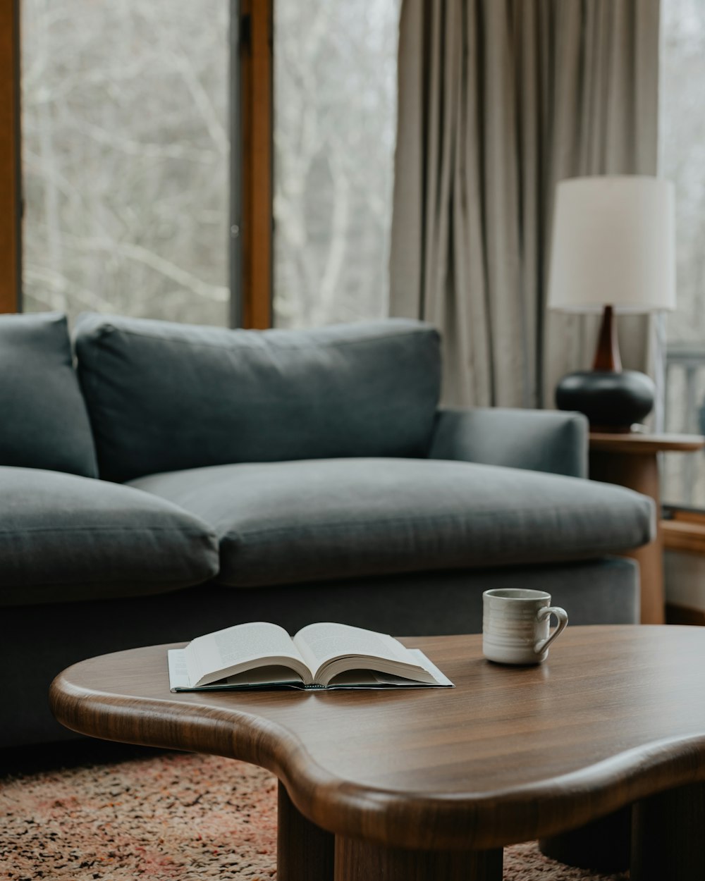 a coffee table with a book and a cup on it