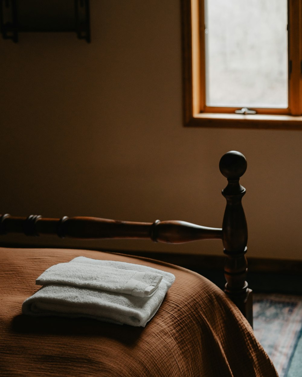 a bed with a blanket and a wooden head board