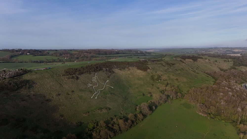 an aerial view of a grassy area with a river running through it