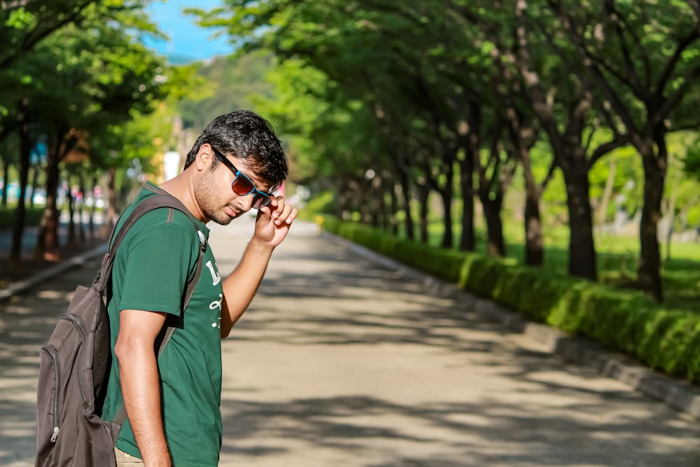 a man in a green shirt is talking on a cell phone