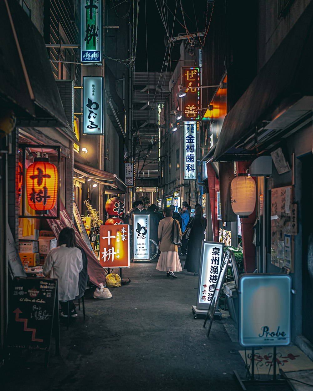 a group of people walking down a street at night