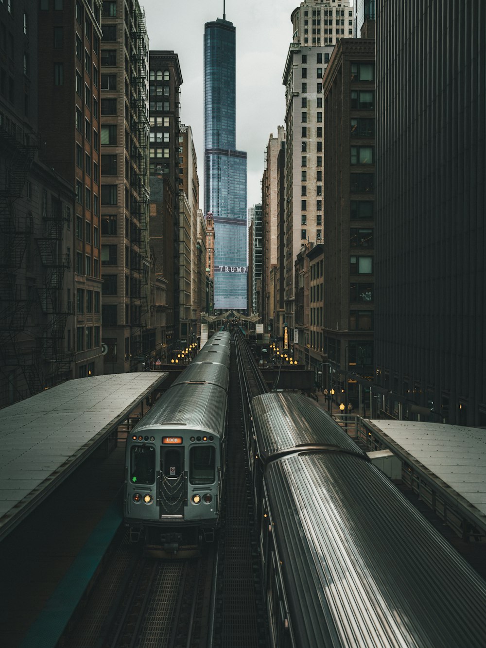 a train traveling through a city next to tall buildings