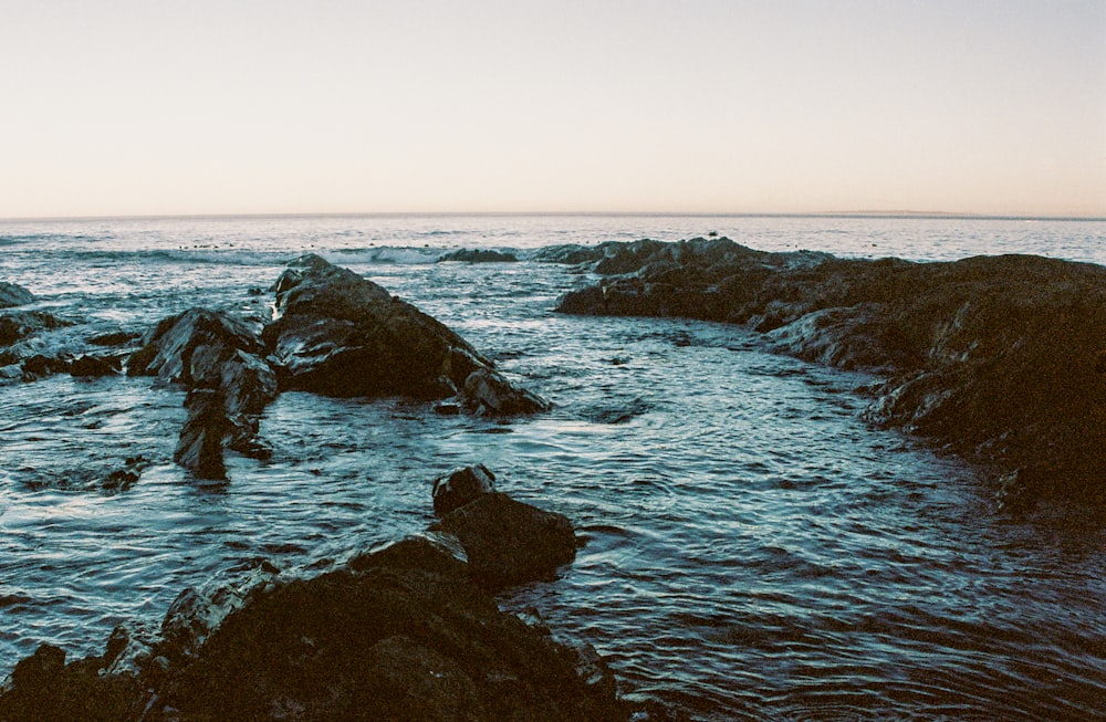 a couple of rocks sitting in the middle of a body of water