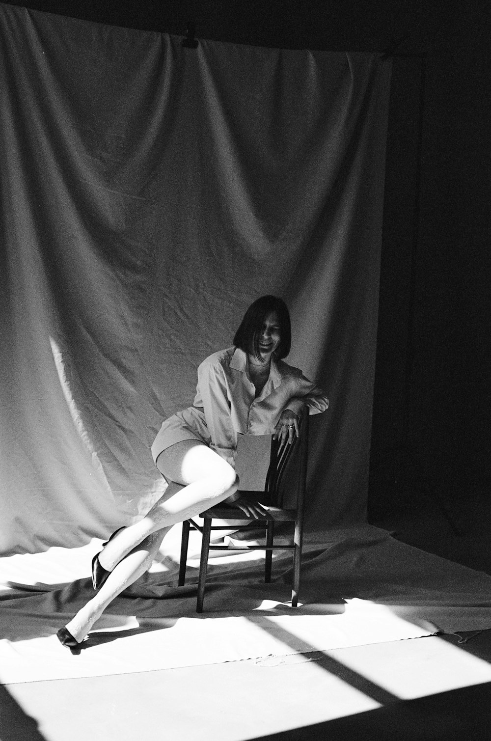 a black and white photo of a woman sitting on a chair