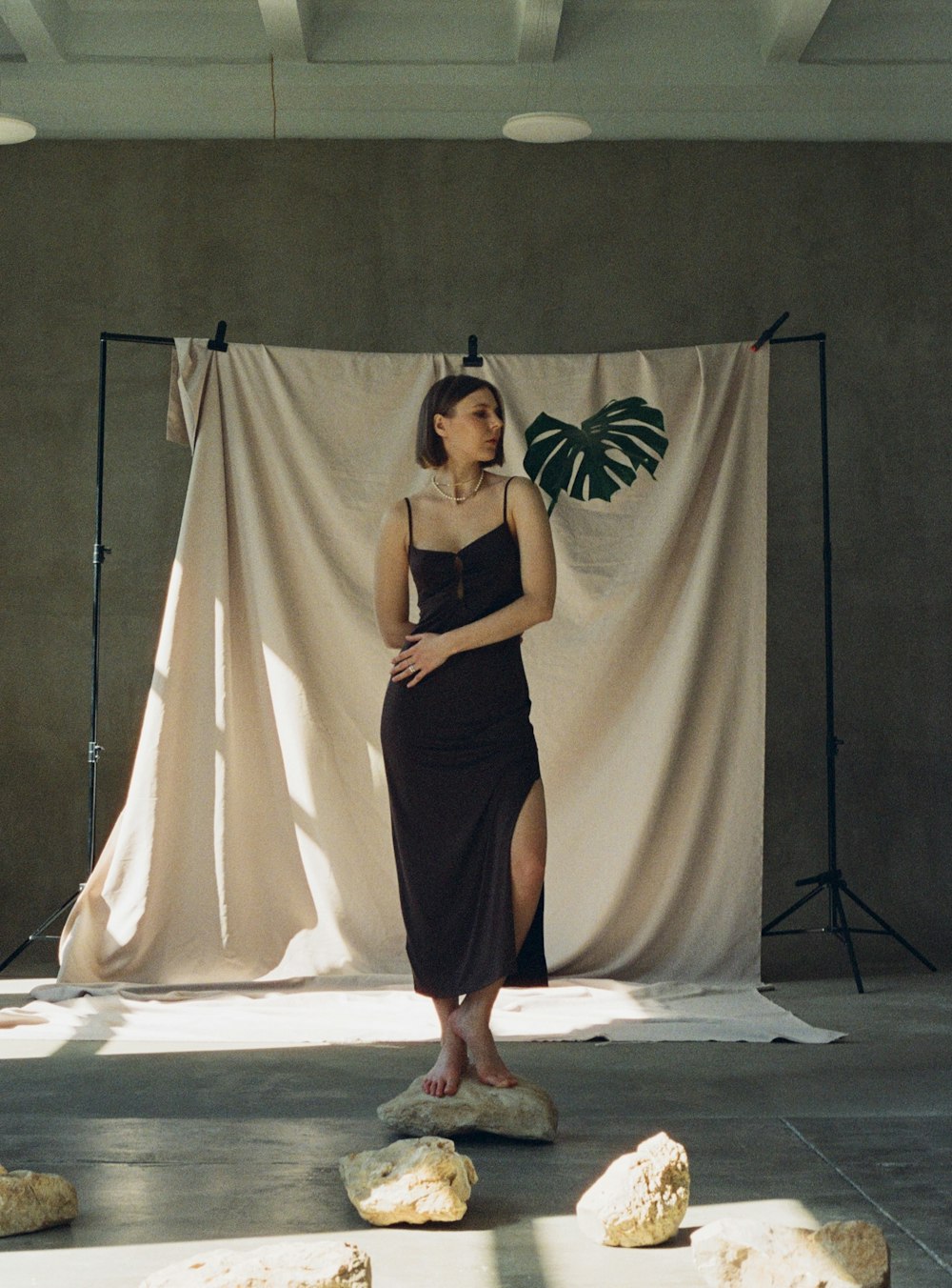 a woman in a black dress standing in front of a backdrop