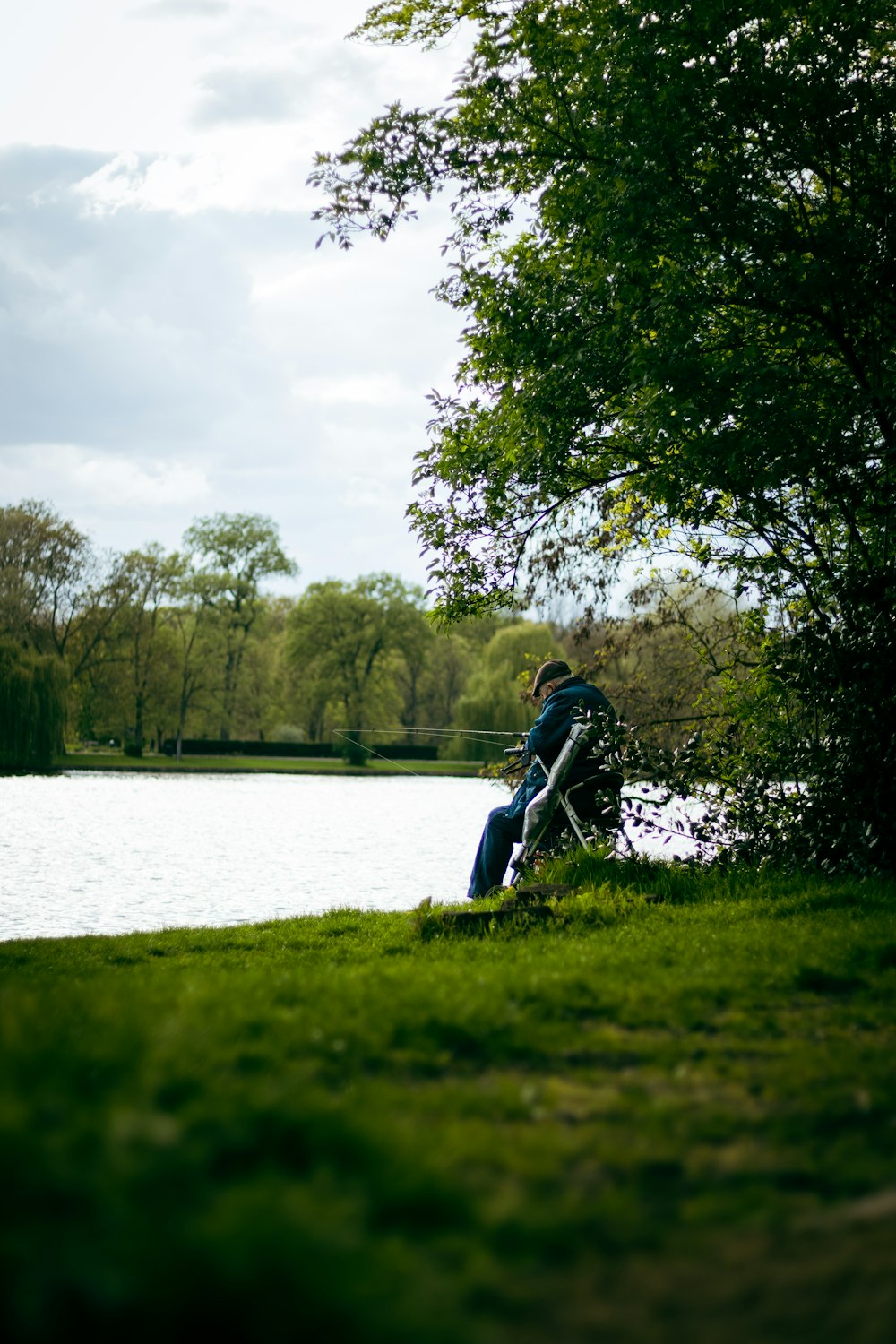 a man sitting on a bench next to a lake