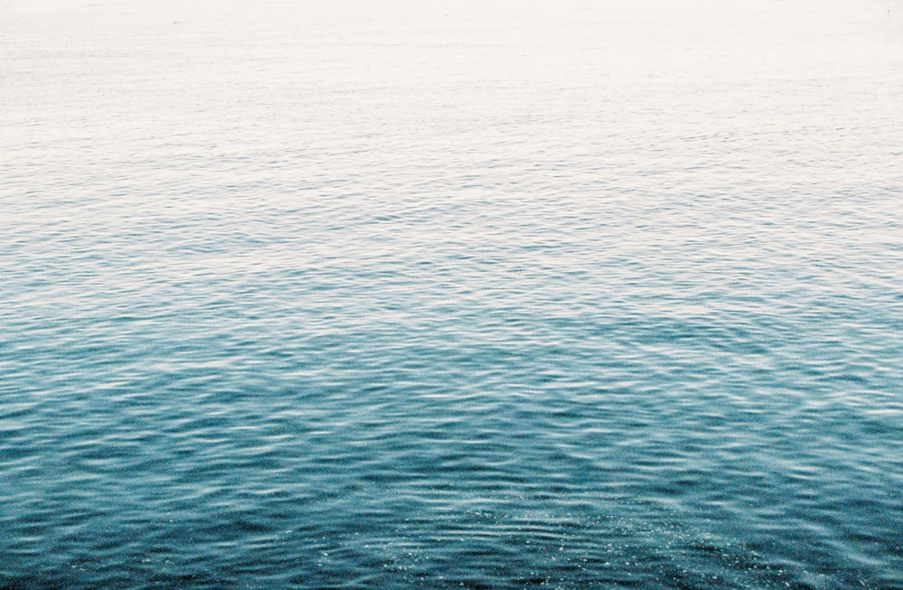 a large body of water with a boat in the distance