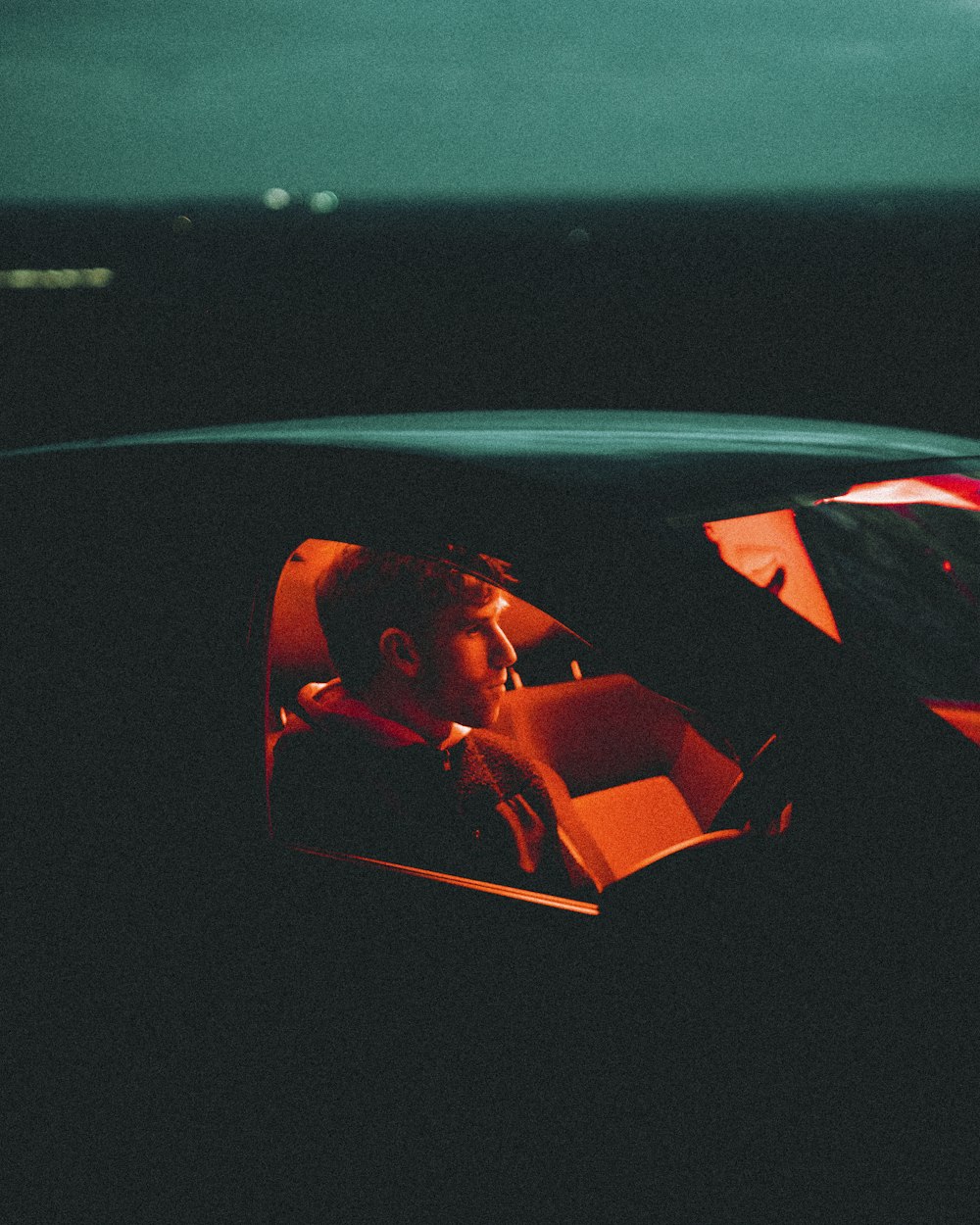  a man sitting in a car in the dark