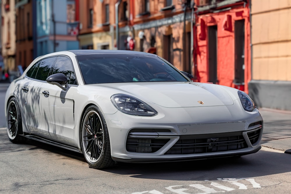 a white porsche panameia parked on the side of the road