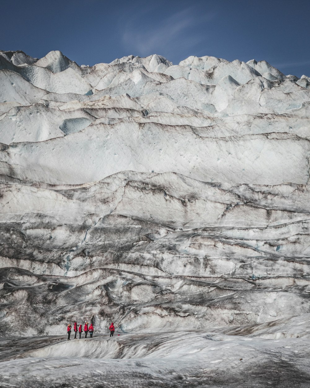 a group of people standing on top of a snow covered mountain