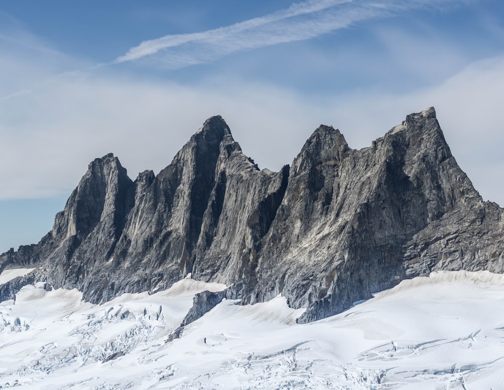 un gruppo di montagne coperte di neve sotto un cielo azzurro