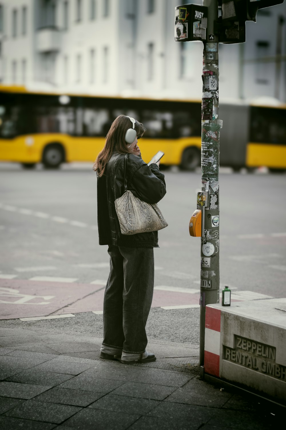 a woman standing next to a pole with a cell phone