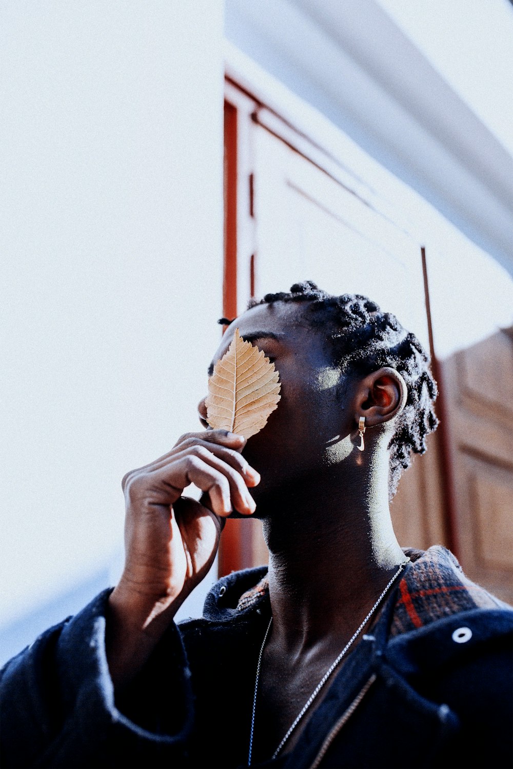 a man holding a leaf up to his face