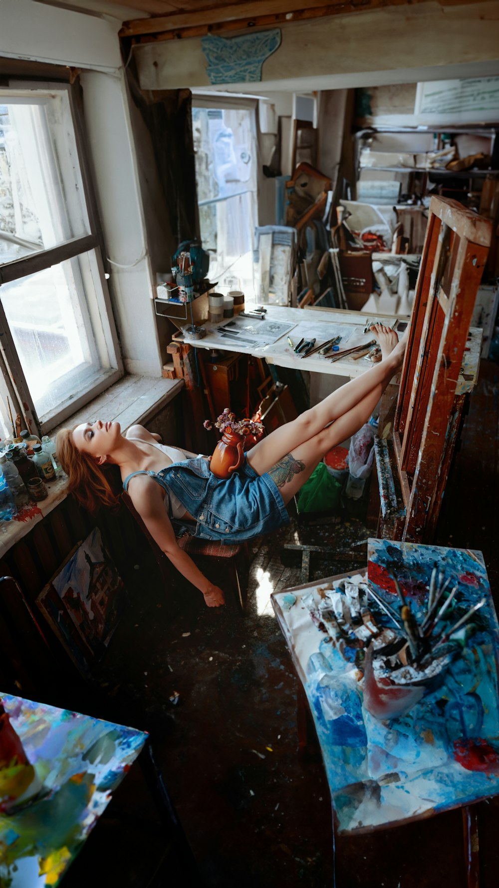 a woman laying on a chair in a messy room